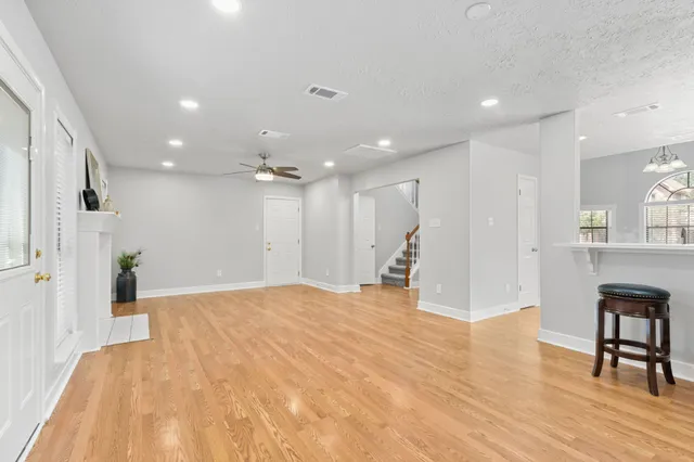 a view of an empty room with kitchen and furniture