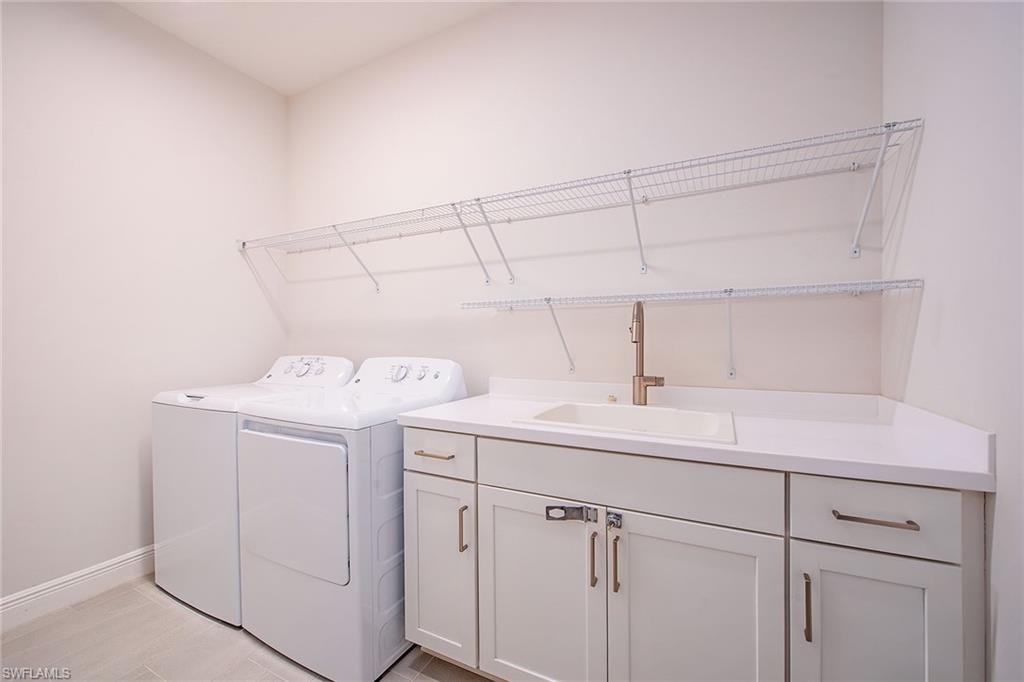 2409 Ariane Drive Naples, FL 34112 - Photo 11 of 16 a utility room with cabinets washer and dryer