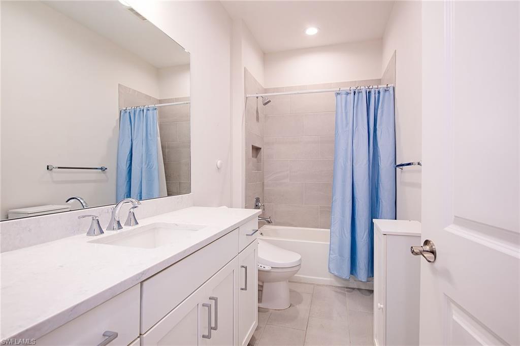 2409 Ariane Drive Naples, FL 34112 - Photo 14 of 16 a bathroom with a sink a toilet a tub and shower