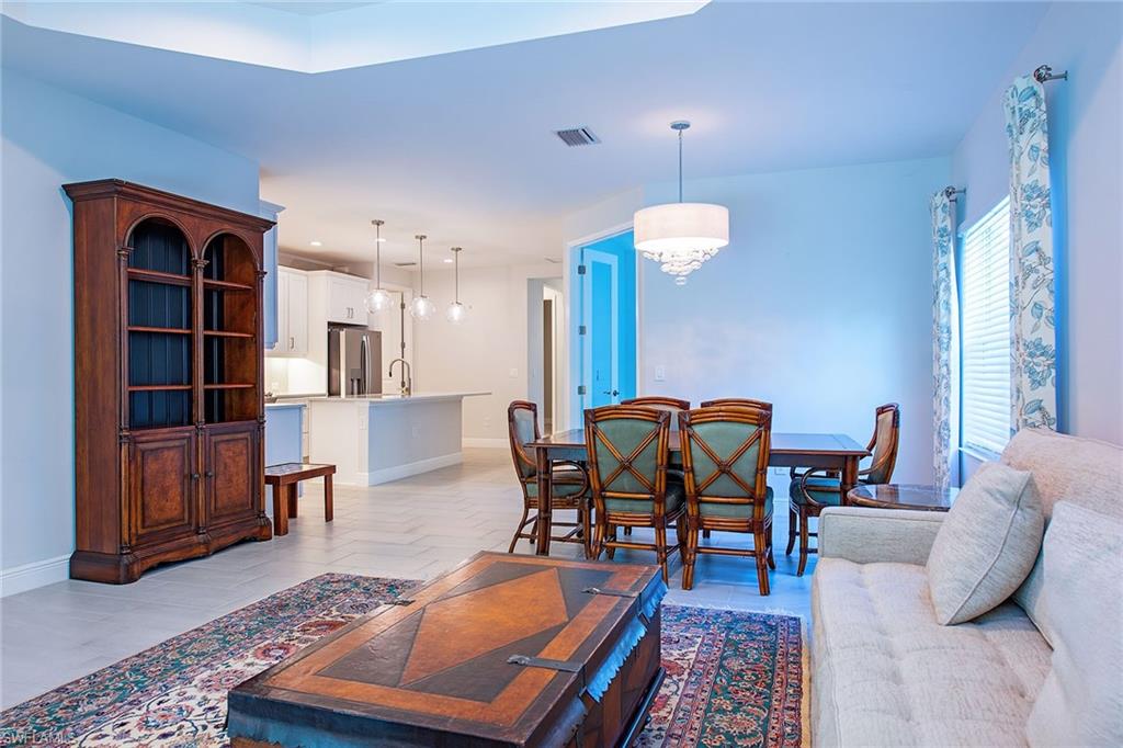 2409 Ariane Drive Naples, FL 34112 - Photo 6 of 16 a living room with furniture a rug and a chandelier