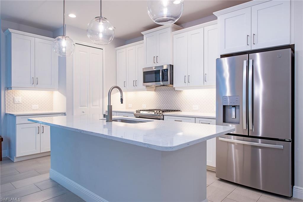 2409 Ariane Drive Naples, FL 34112 - Photo 8 of 16 a kitchen with kitchen island a counter top space stainless steel appliances and cabinets