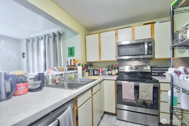 a kitchen with stainless steel appliances granite countertop a sink stove and cabinets
