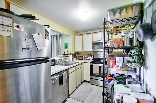 a kitchen with stainless steel appliances a sink and a refrigerator