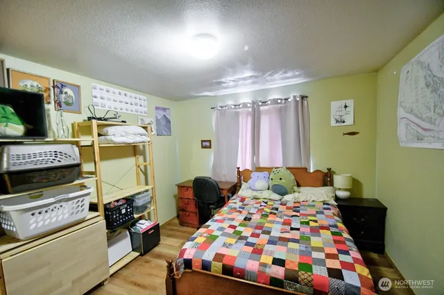 a bedroom with a bed a flat screen tv and a window