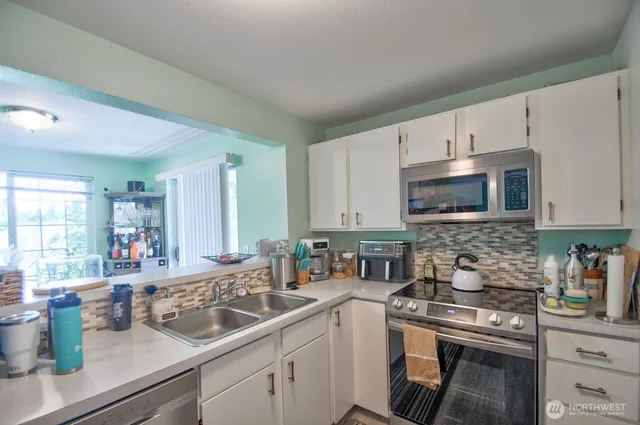 a kitchen with a sink stove top oven and microwave