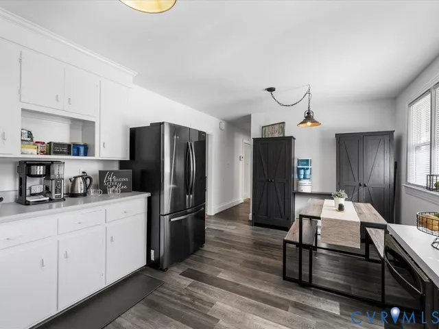 a kitchen with stainless steel appliances kitchen island granite countertop a refrigerator a stove and a sink with wooden floor