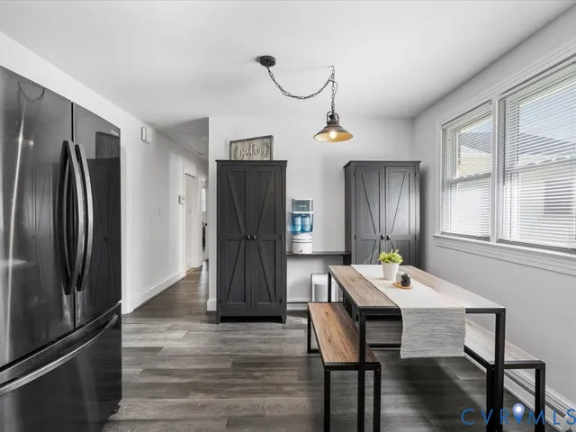 a kitchen with stainless steel appliances refrigerator dining table and chairs