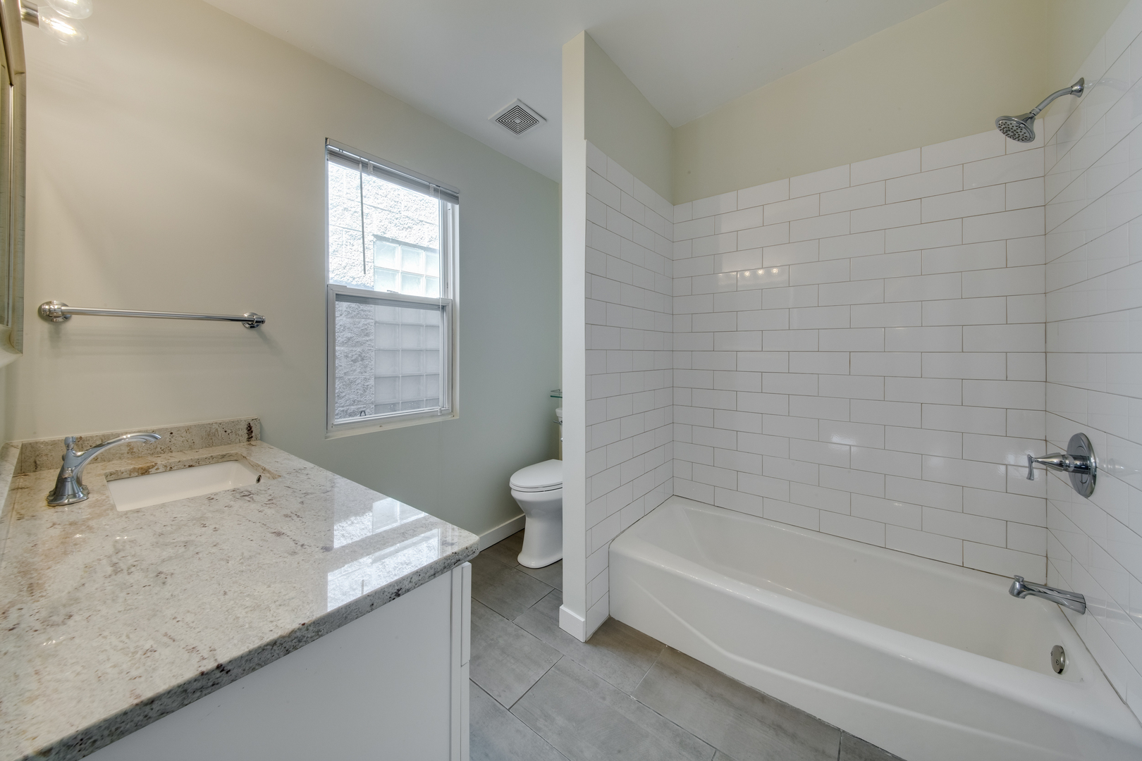 1246 North Cleaver Street, Unit 2R Chicago, IL 60642 - Photo 13 of 15 a bathroom with a granite countertop sink and a bathtub