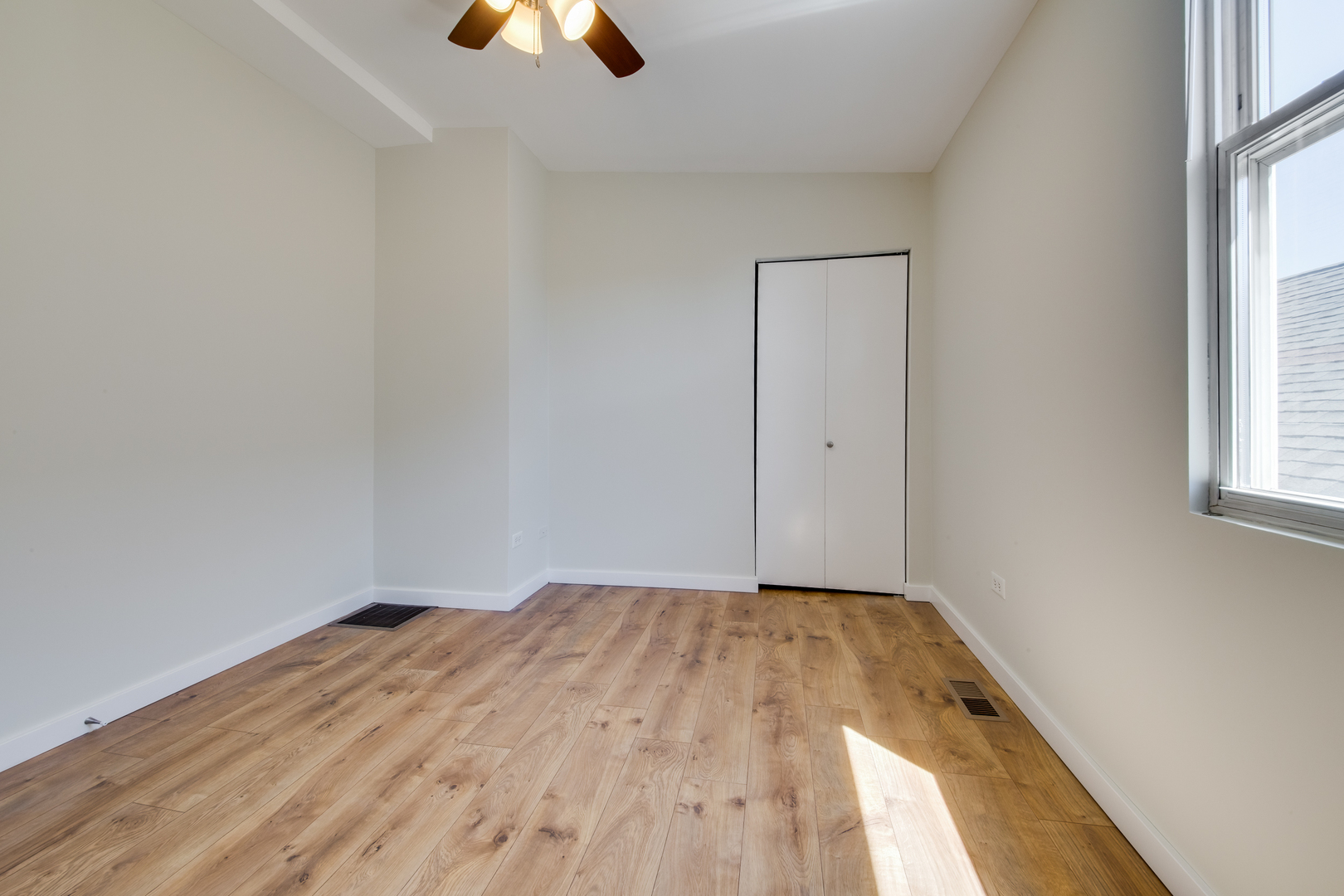 1246 North Cleaver Street, Unit 2R Chicago, IL 60642 - Photo 10 of 15 an empty room with windows and fan