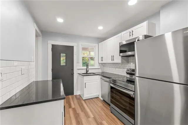 a kitchen with a refrigerator and a stove top oven
