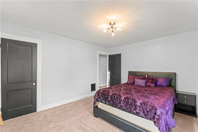 a bedroom with a large bed and a chandelier