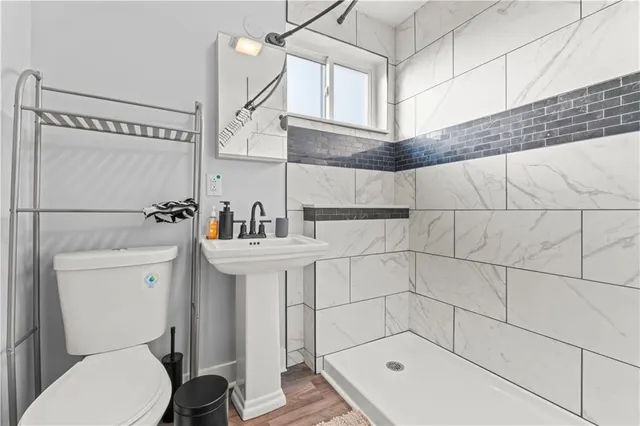 a bathroom with a sink a toilet and shower