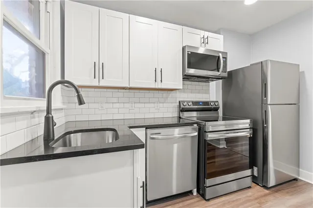 a kitchen with stainless steel appliances granite countertop a refrigerator sink and stove