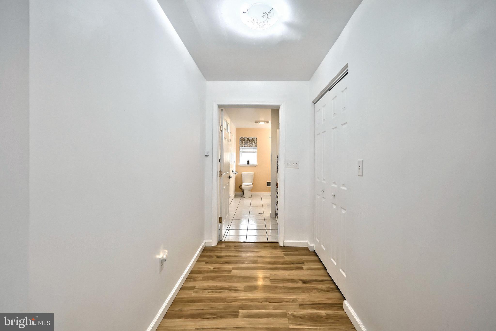 4619 South Road Harrisburg, PA 17109 - Photo 16 of 29 a view of a hallway with wooden floor and a bathroom