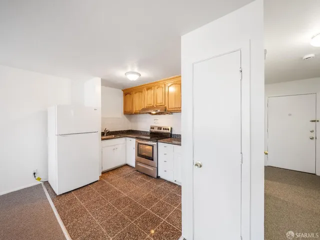 a kitchen with stainless steel appliances granite countertop a sink a stove and a refrigerator