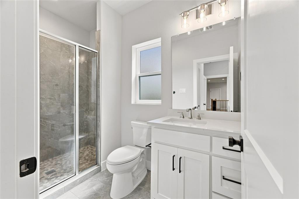 3820 Jack's Loop Midlothian, TX 76065 - Photo 36 of 40 Shower with glass enclosure, white vanity with integrated sink, rectangular mirror, and window