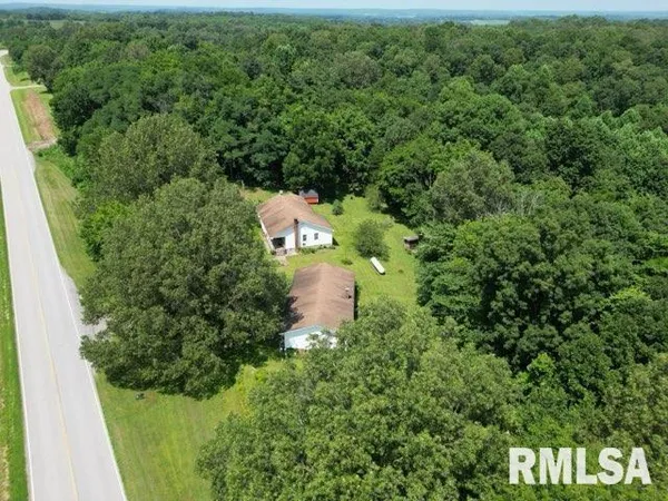 an aerial view of a house with a yard and outdoor seating