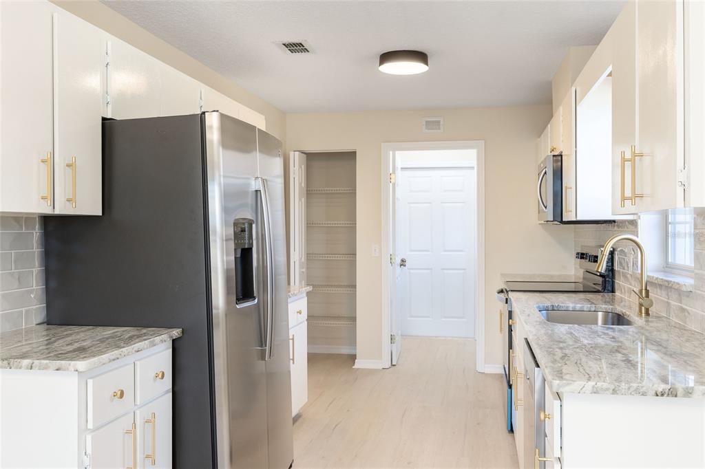 17549 Southeast 115th Terrace Road Summerfield, FL 34491 - Photo 11 of 56 a kitchen with a refrigerator sink and cabinets