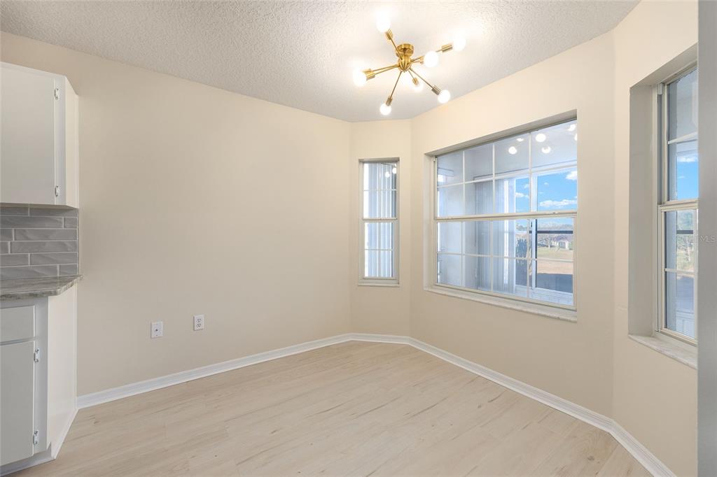 17549 Southeast 115th Terrace Road Summerfield, FL 34491 - Photo 21 of 56 an empty room with a chandelier fan and windows