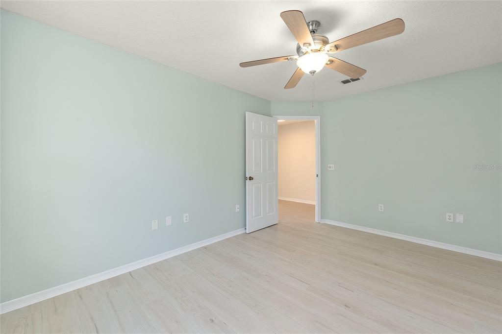 17549 Southeast 115th Terrace Road Summerfield, FL 34491 - Photo 32 of 56 an empty room with a chandelier fan and windows