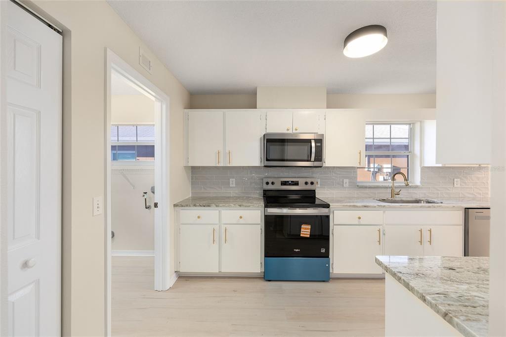 17549 Southeast 115th Terrace Road Summerfield, FL 34491 - Photo 6 of 56 a kitchen with stainless steel appliances granite countertop a stove top oven a sink and a refrigerator