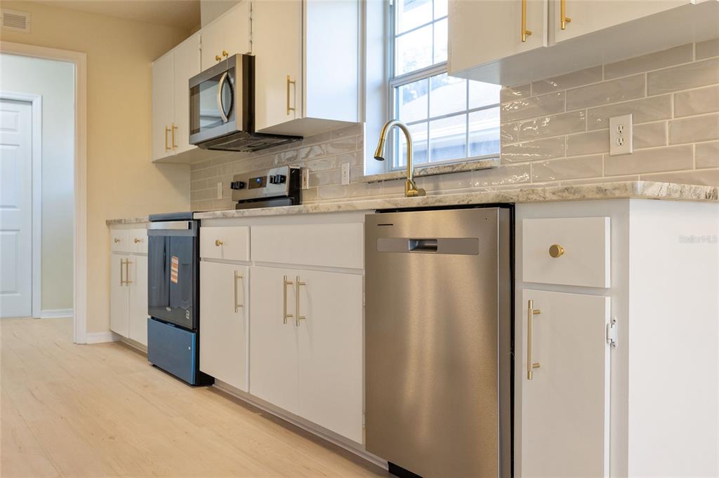 17549 Southeast 115th Terrace Road Summerfield, FL 34491 - Photo 9 of 56 a kitchen with stainless steel appliances granite countertop a refrigerator and a sink
