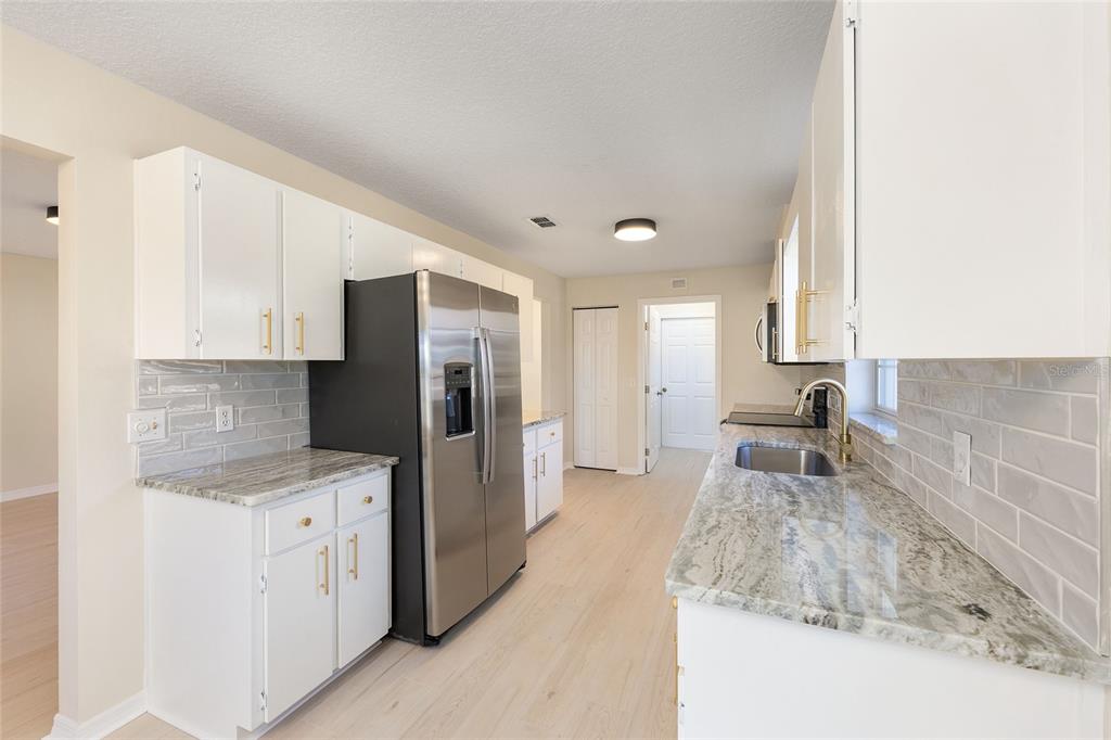 17549 Southeast 115th Terrace Road Summerfield, FL 34491 - Photo 10 of 56 a kitchen with a refrigerator sink and cabinets