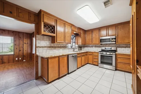 a kitchen with stainless steel appliances granite countertop a stove sink and cabinets