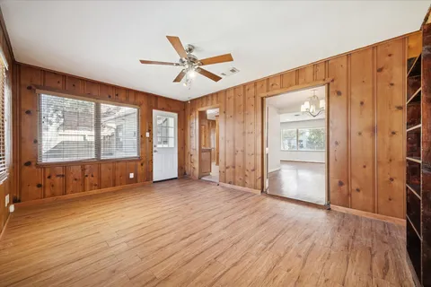 a view of an empty room with a window and wooden floor