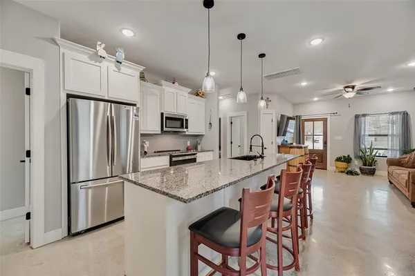 a kitchen with granite countertop a center island a stove and a wooden floor