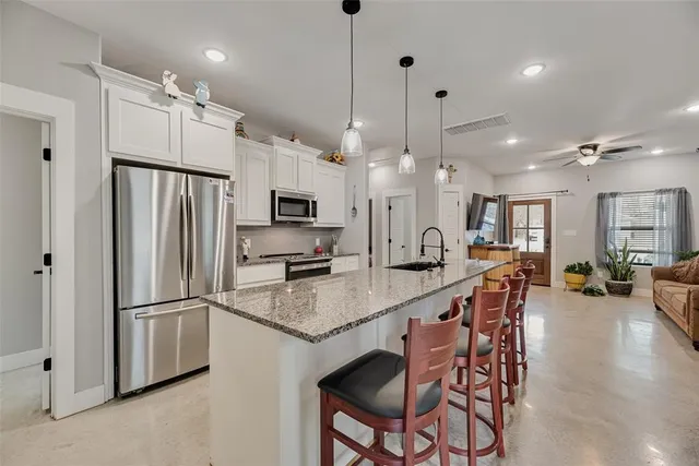 a kitchen with granite countertop a center island a stove and a wooden floor