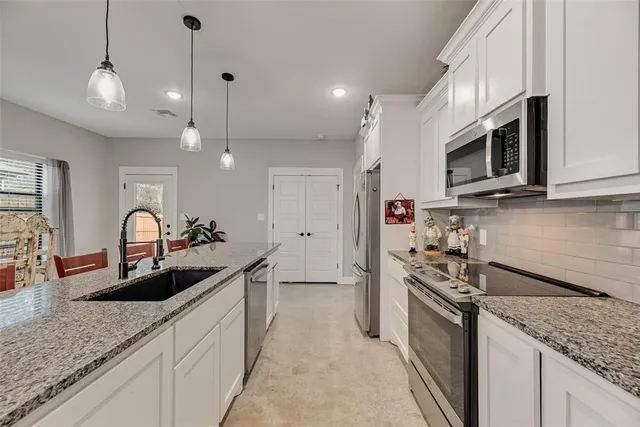 a kitchen with stainless steel appliances granite countertop a stove microwave and refrigerator
