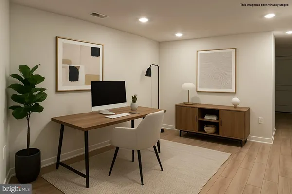 a view of a hallway with wooden floor and a bathroom