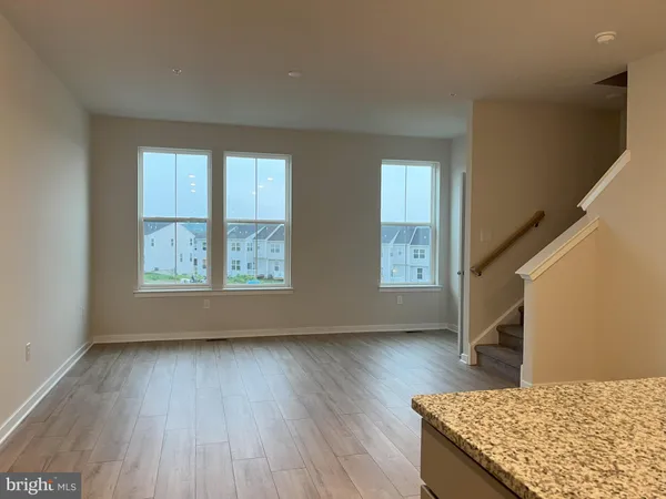 a view of an empty room and wooden floor windows