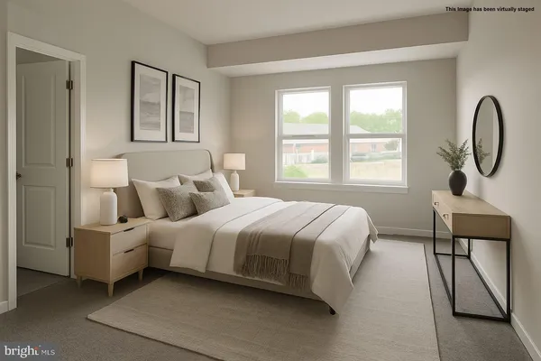 a spacious bedroom with a bed a mirror and a large window