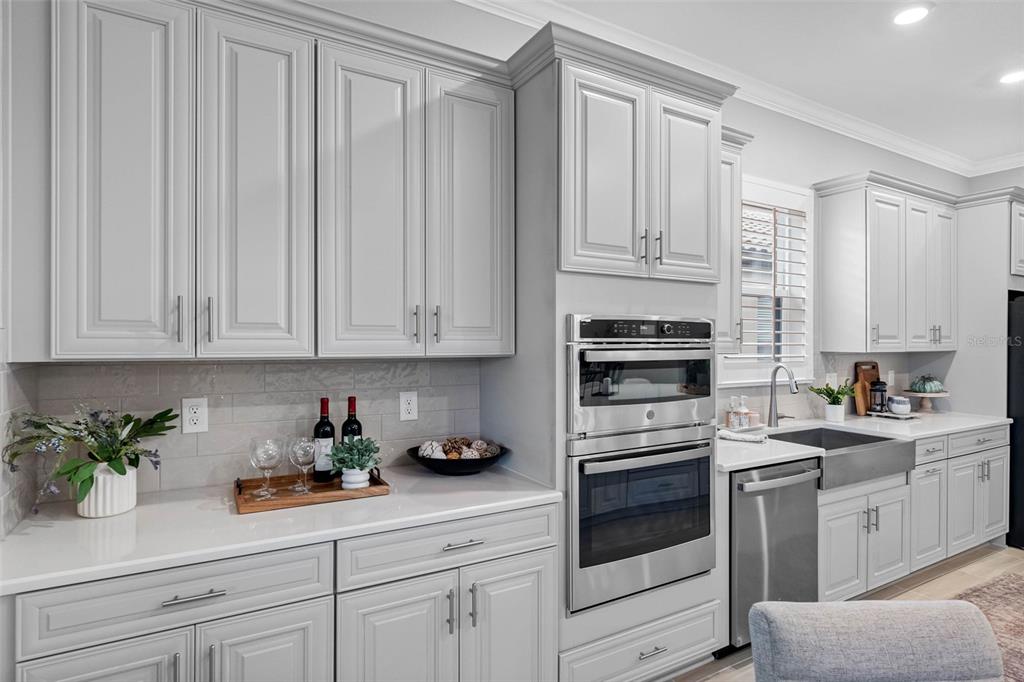 4795 Freccia Loop Wesley Chapel, FL 33543 - Photo 16 of 51 a kitchen with white cabinets and white appliances