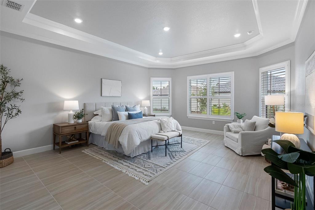 4795 Freccia Loop Wesley Chapel, FL 33543 - Photo 21 of 51 a spacious bedroom with a bed and wooden floor