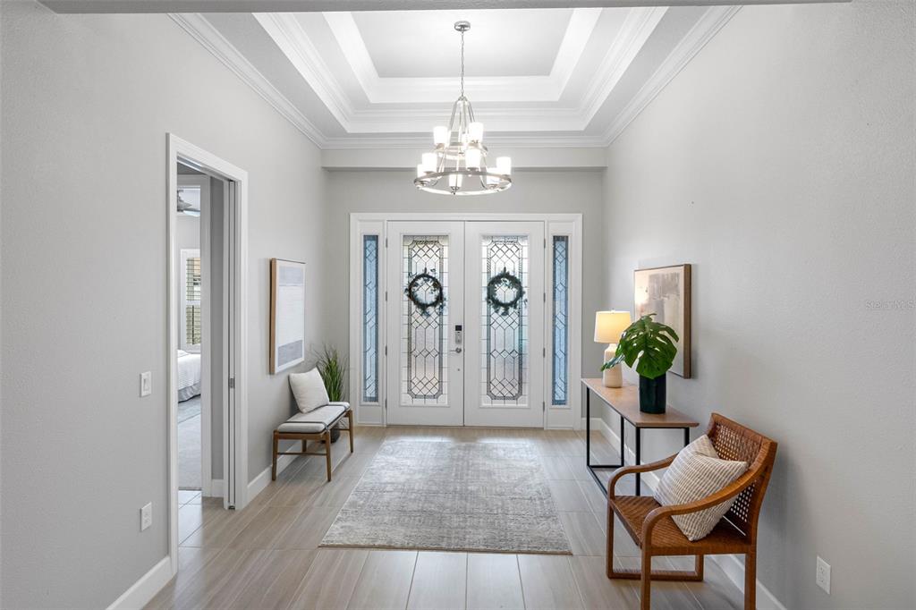 4795 Freccia Loop Wesley Chapel, FL 33543 - Photo 5 of 51 a living room with furniture a chandelier and a rug