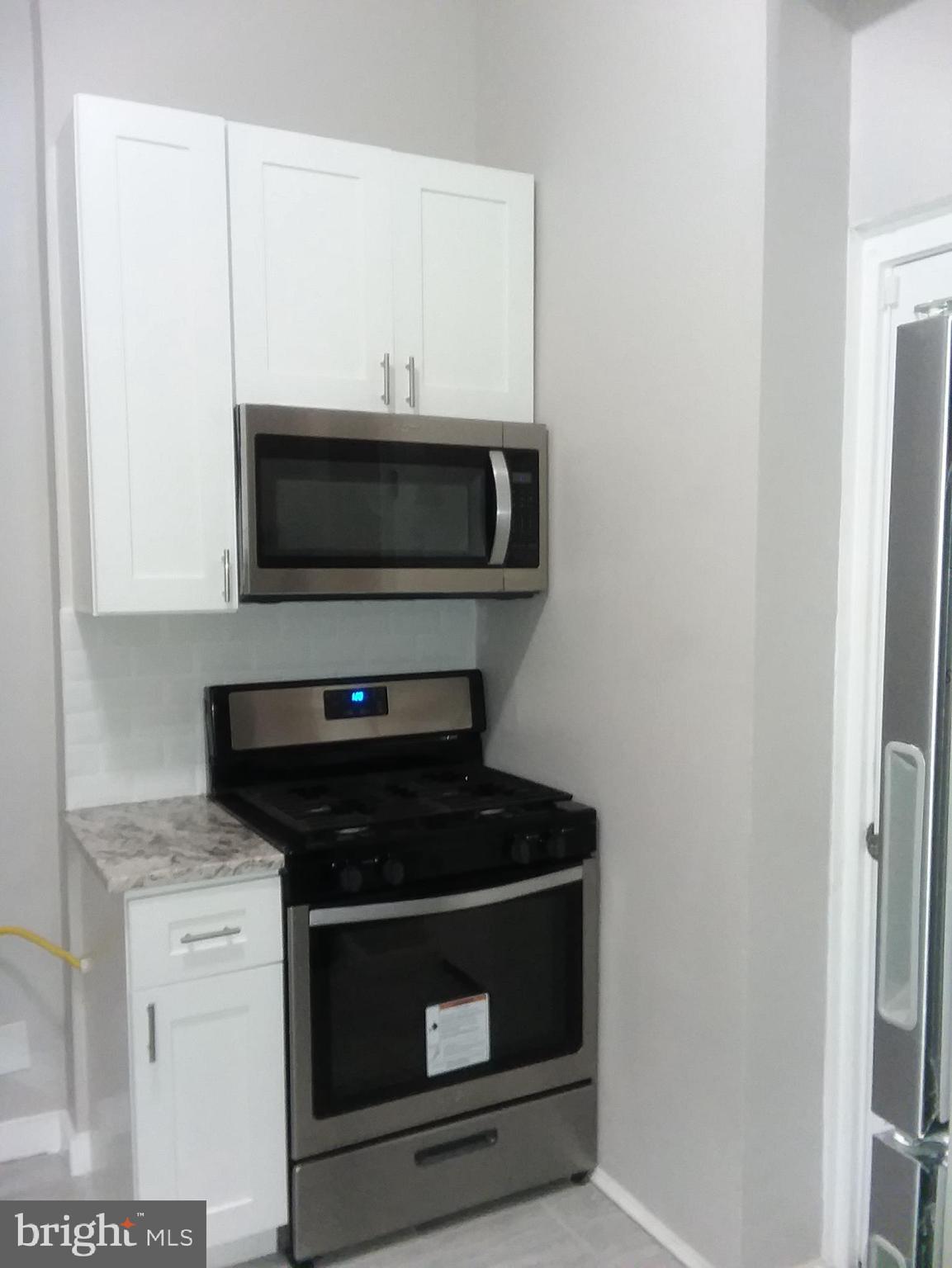 2012 Mt Royal Terrace, Unit 4 Baltimore, MD 21217 - Photo 17 of 55 a kitchen with microwave cabinets and stove top oven
