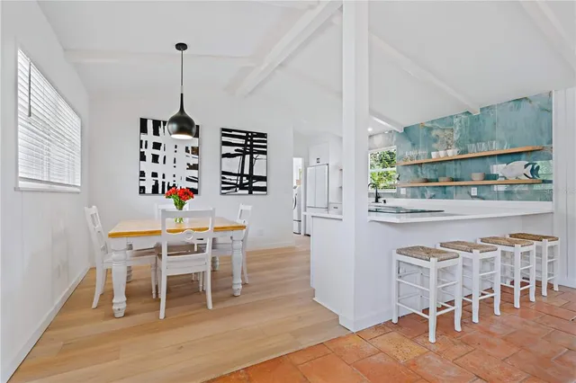 a dining room with furniture a chandelier and wooden floor