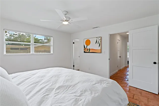 a bedroom with a large bed and a chandelier