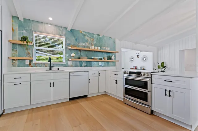 a kitchen with white cabinets and stainless steel appliances