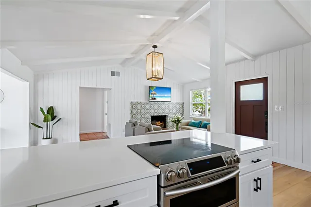 a kitchen with granite countertop a stove and a white cabinets