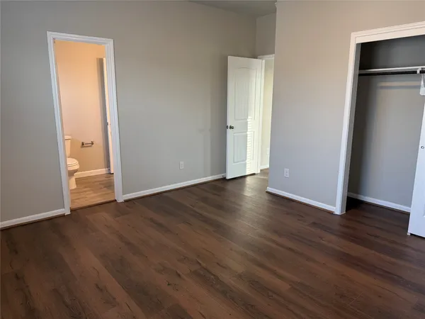 an empty room with wooden floor and closet