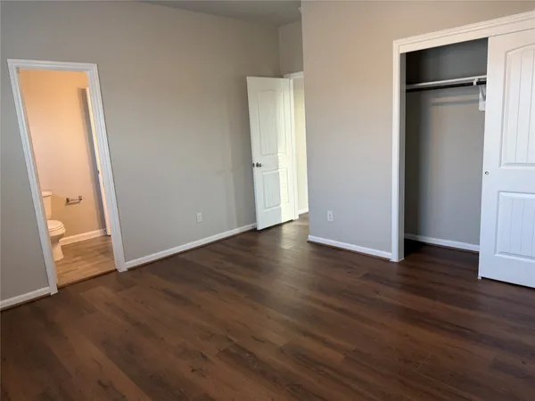 an empty room with wooden floor and closet
