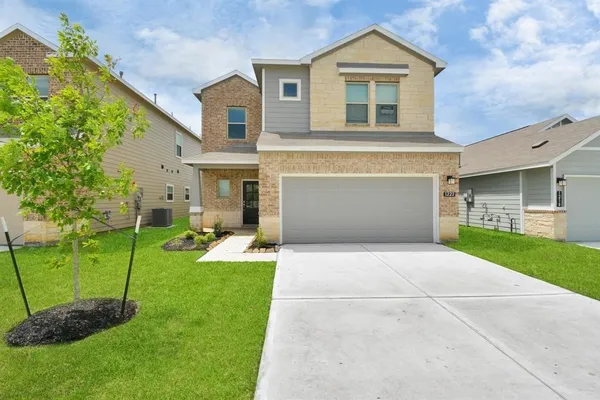 a front view of a house with a yard and trees