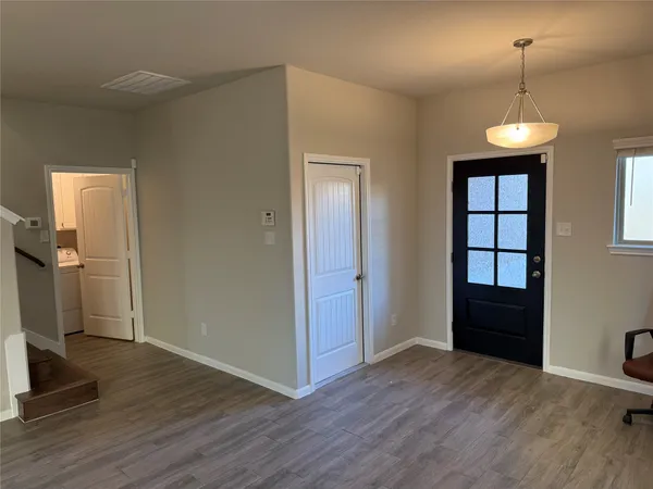 a view of empty room with wooden floor and window