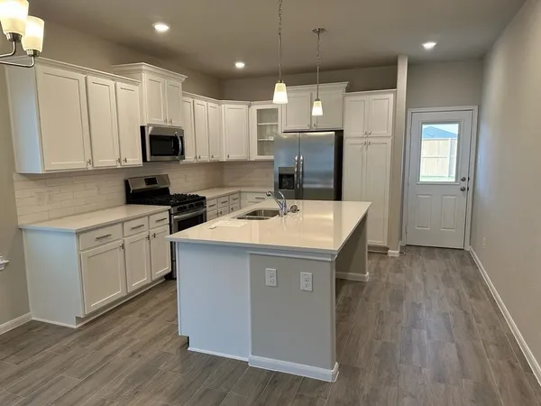 a kitchen with a sink a stove a refrigerator and cabinets