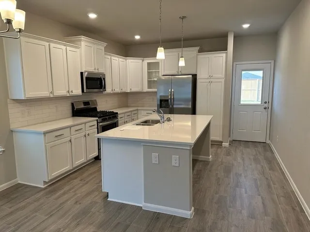 a kitchen with a sink a stove a refrigerator and cabinets