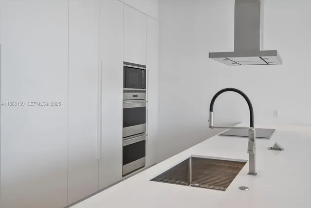 a close view of a sink a faucet and appliance in the kitchen